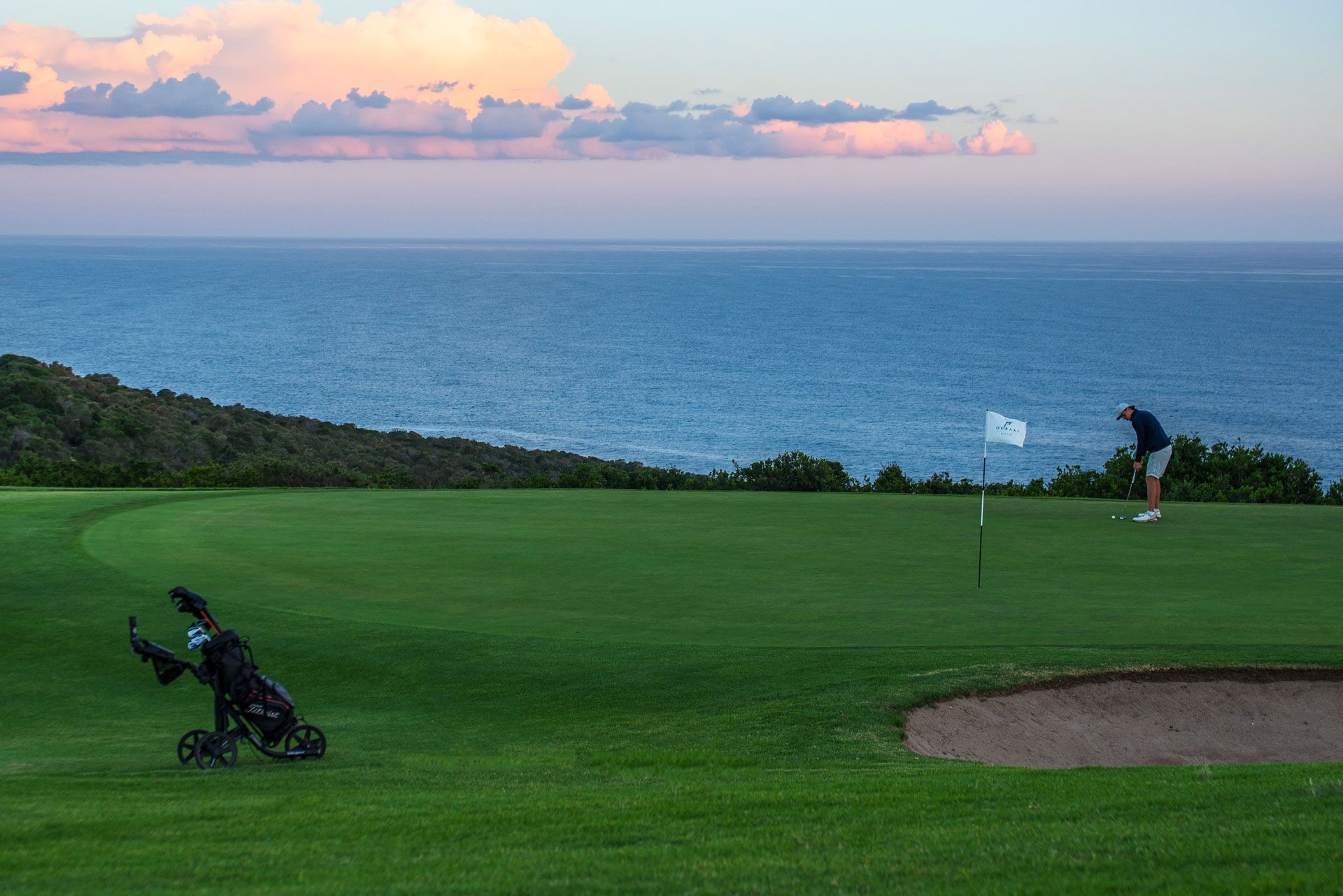 Oubaai Golf Estate Man Putting On Green With Ocean Behind